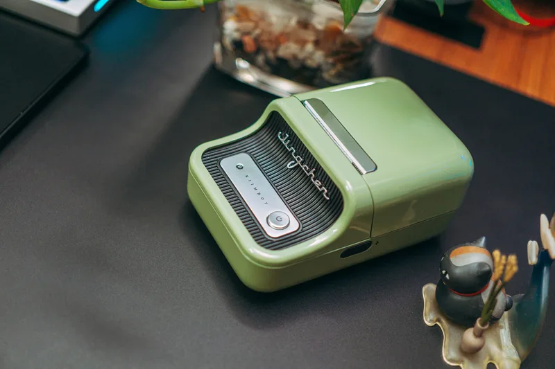 Printer label thermal portable berwarna hijau di atas meja kerja