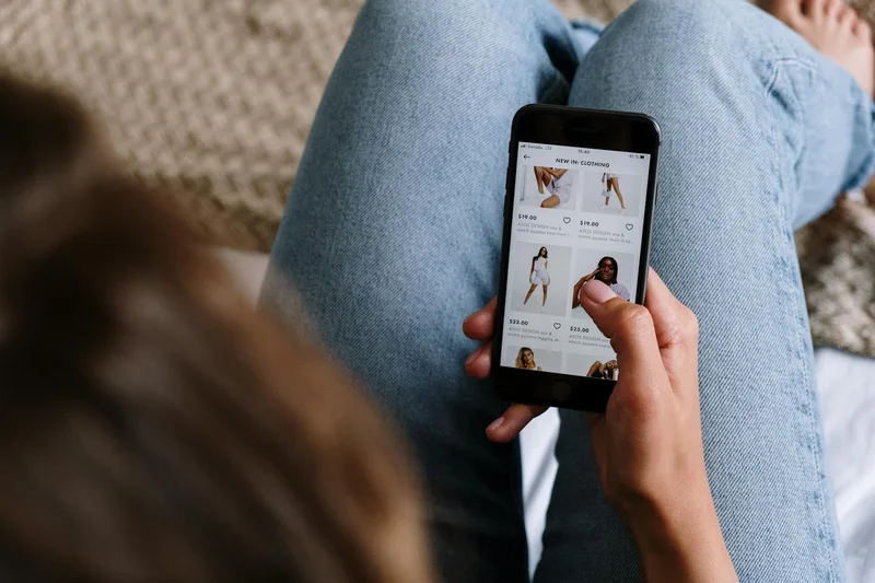 Pengguna smartphone mengakses aplikasi e-commerce untuk memantau transaksi dan laporan penjualan