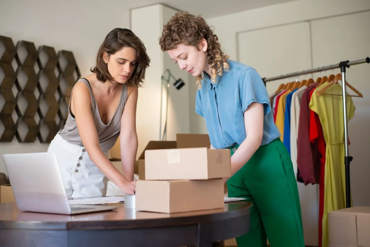 Dua reseller mengemas produk pesanan online ke dalam kardus untuk dikirim ke pembeli