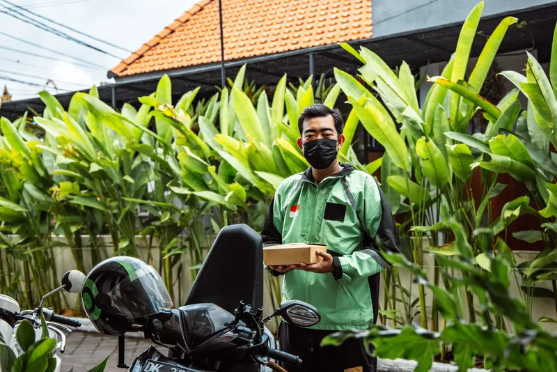 Kurir motor mengambil paket kiriman dari penjual