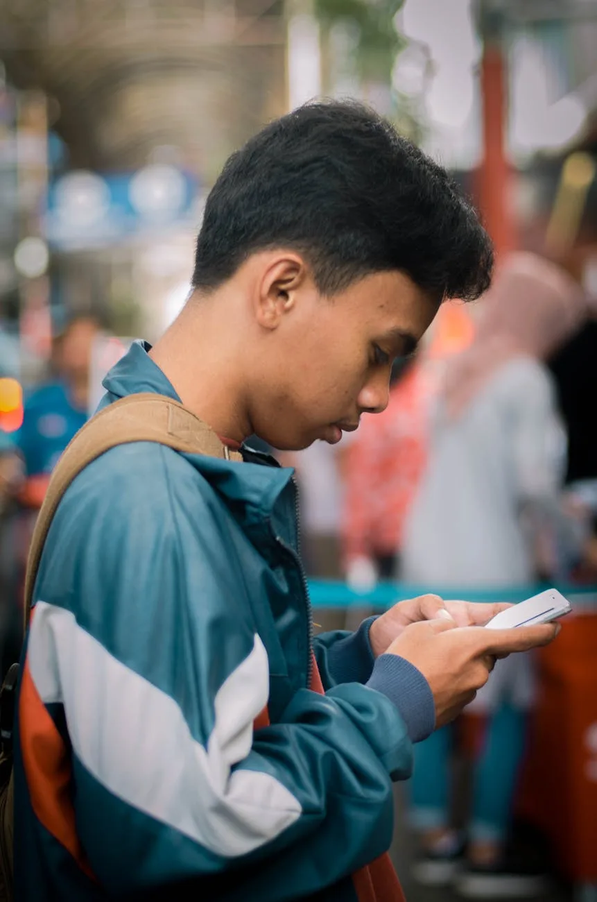 Ilustrasi: seorang pemuda menggunakan smartphone di luar ruangan untuk mengakses aplikasi