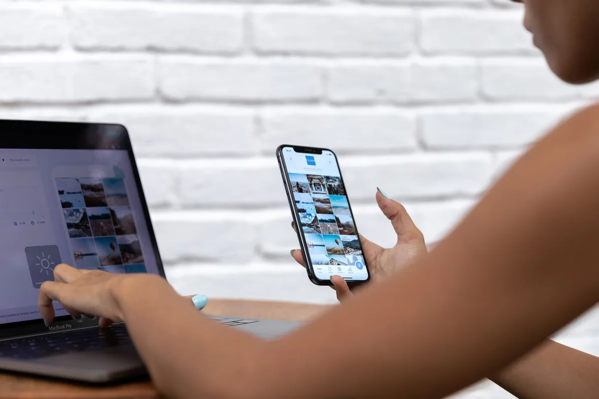 Wanita bekerja menggunakan laptop dan telefon pintar untuk kandungan media sosial dan kongsi pautan produk