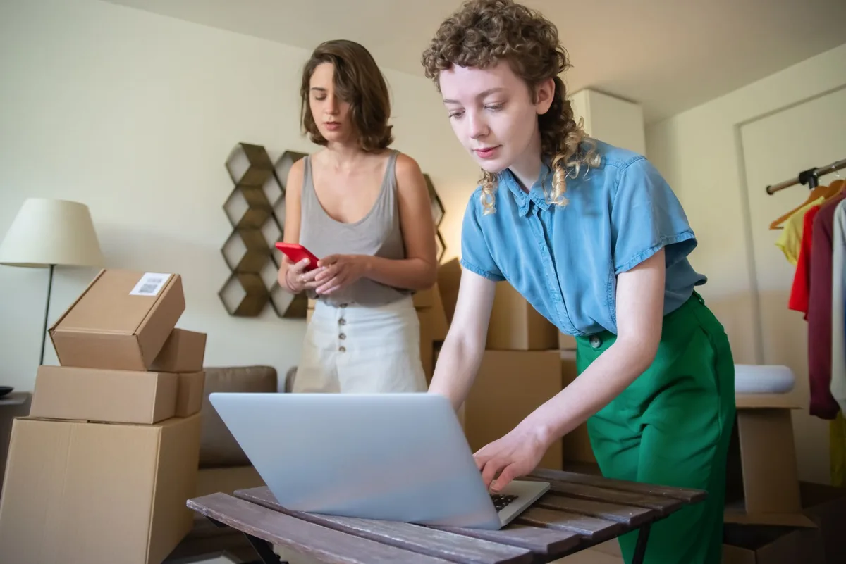 Shopee Philippines seller managing logistics and courier settings on a laptop at a desk with packaged orders